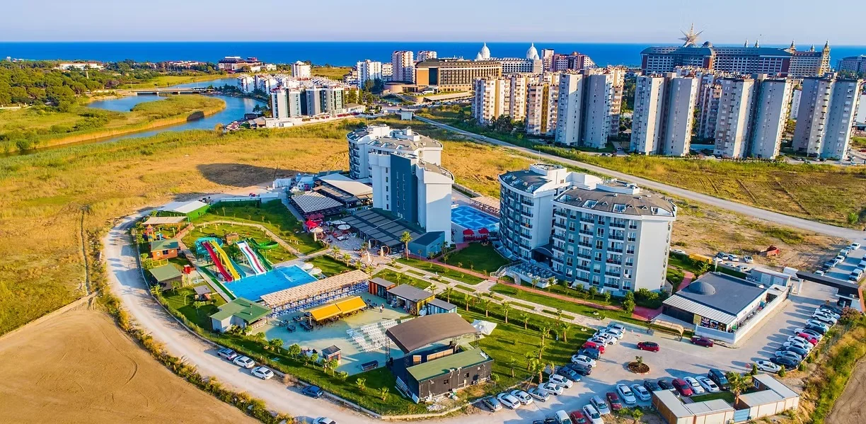 Solena Lara Hotel'in otel binaları, aquaparkı ve havuzlarının, arkada denizle birlikte kuş bakışı görünümü